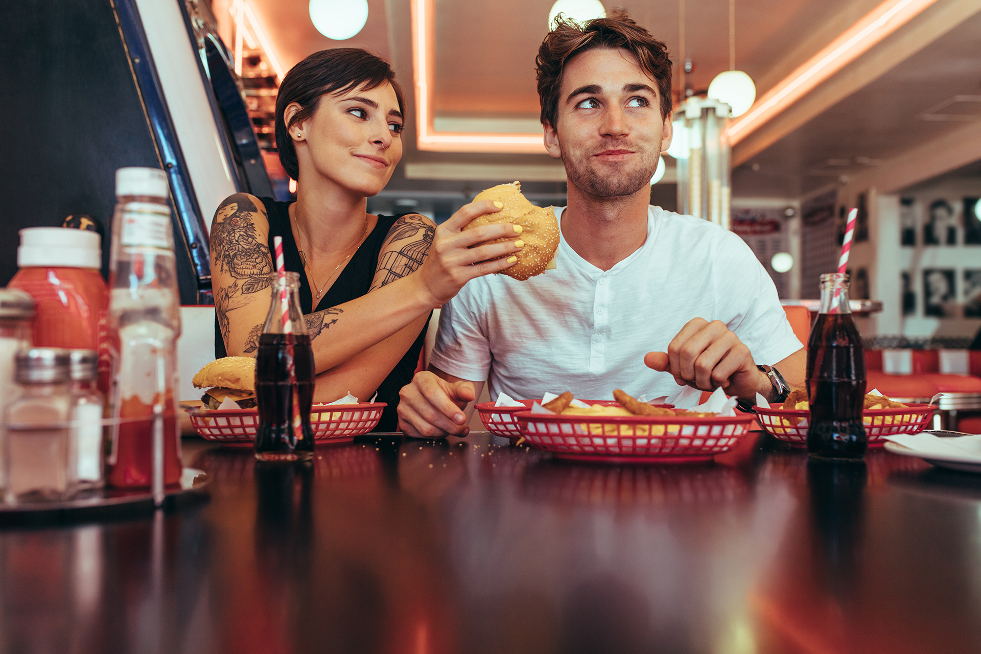 En kvinde og en mand spiser på en burgerrestaurant.